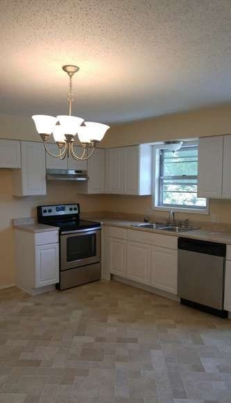 After: a modern kitchen with new tile, cabinets, and modern appliances