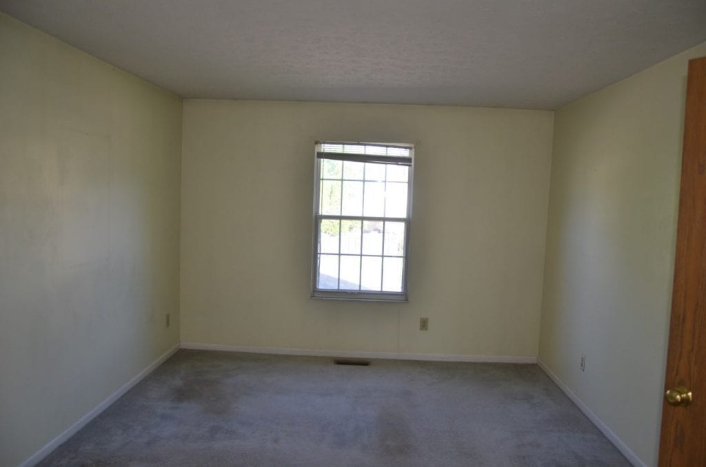 Before: an older interior with outdated old paint and carpet