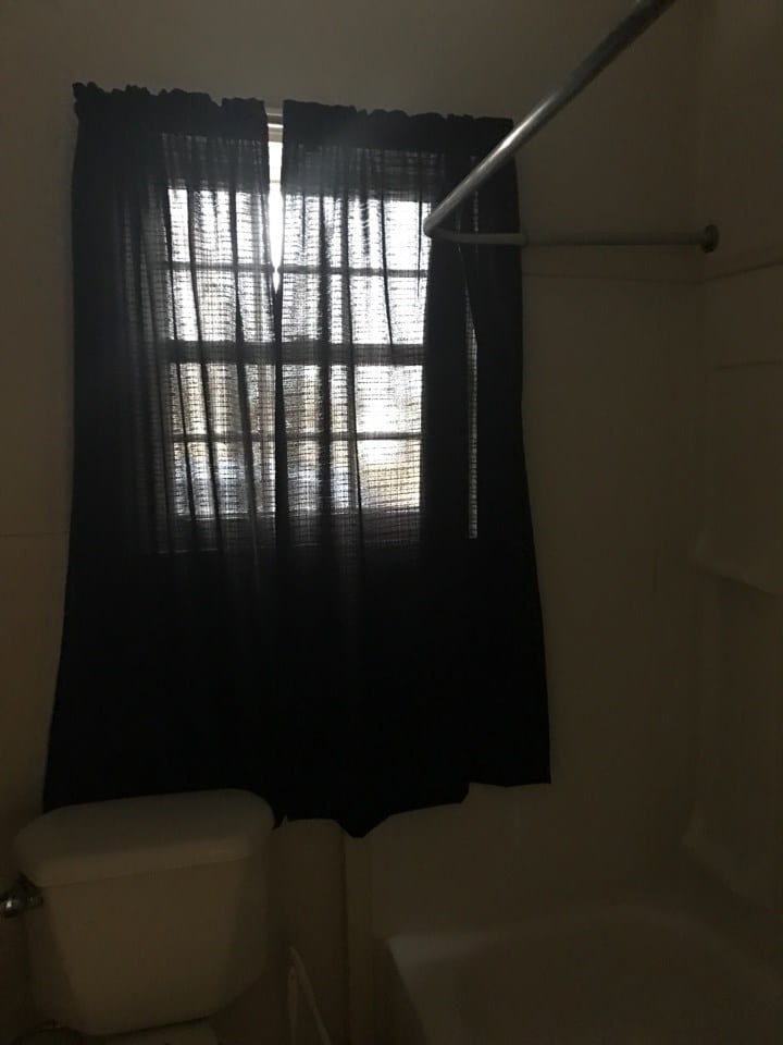 Before: see-through curtains on a window in a bathroom