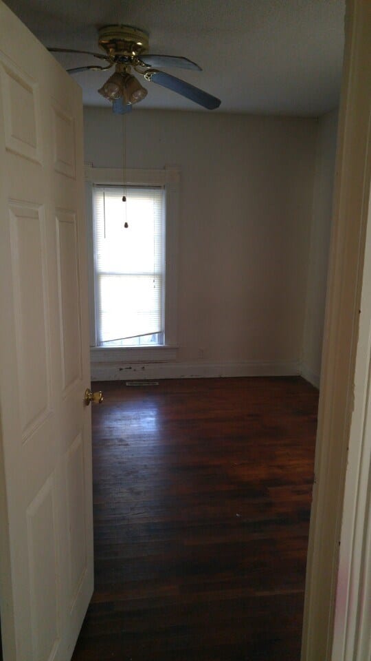 Before: an older interior room with unmaintained wood flooring