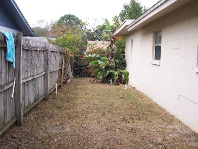 Before: a house with fading paint and an overgrown side yard